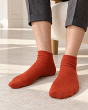 Laden Sie das Bild in den Galerie-Viewer, TITTIMITTI men’s Copper 100% organic combed cotton socks worn on a model, Made in Italy
