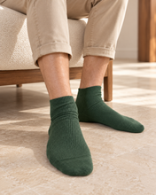 Laden Sie das Bild in den Galerie-Viewer, TITTIMITTI men’s Olive 100% organic combed cotton crew socks worn on feet, Made in Italy
