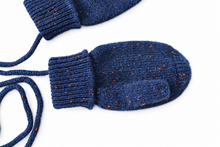 Laden Sie das Bild in den Galerie-Viewer, Close-up of TITTIMITTI Stardust navy 100% cashmere baby and kids’ mittens showing blue and orange flecks, knit texture, separate thumb and ribbed cuff